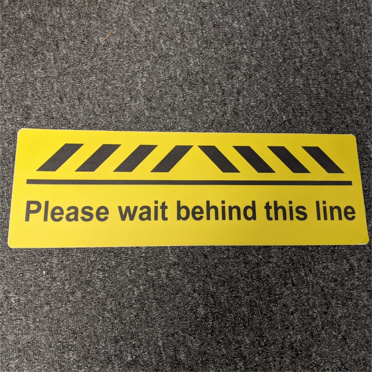 floor sticker informing customers where to stand when waiting