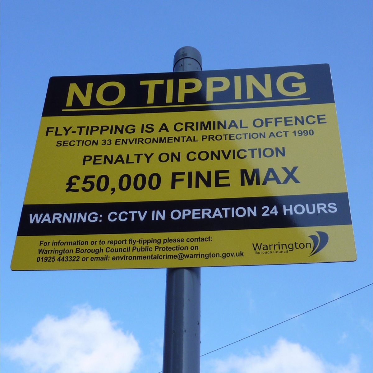 no fly tipping sign mounted to a lamppost