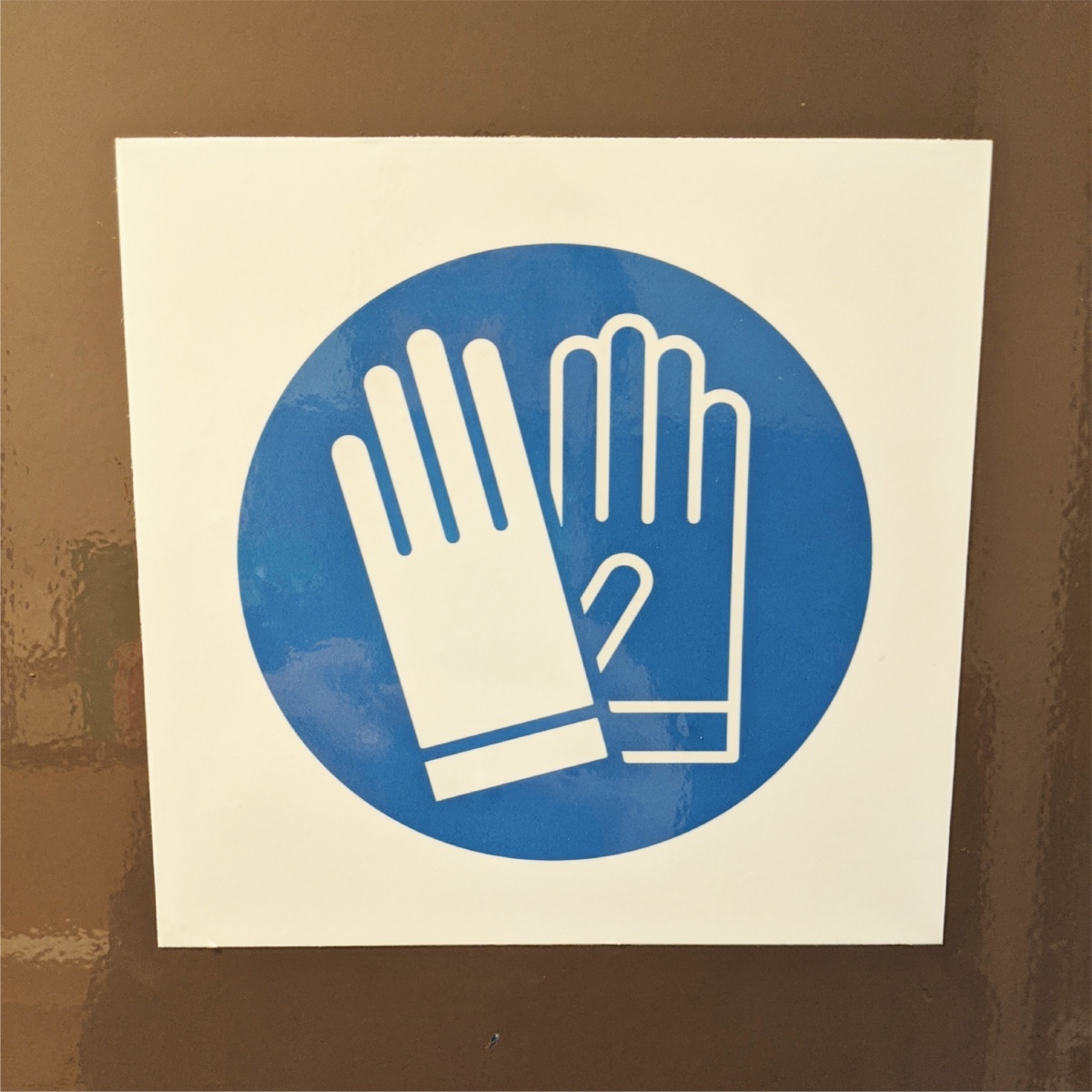 sticker showing gloves are needed in the following area
