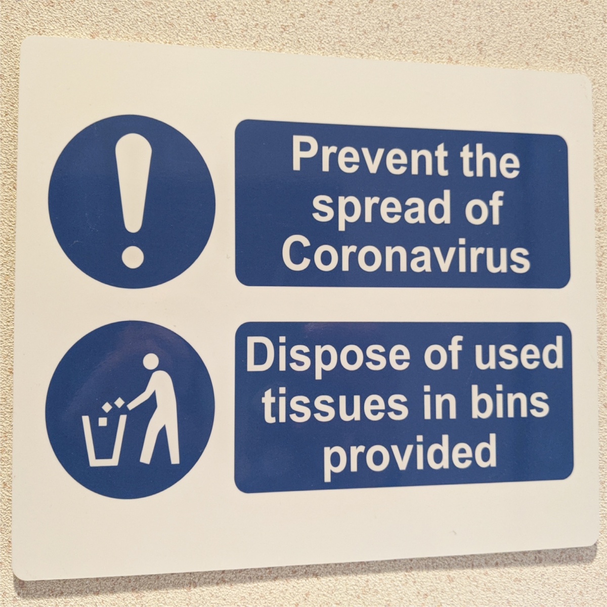 information sign advising people to dispose of used tissues in nearby bin