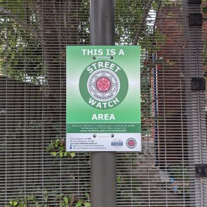 green street watch sign mounted to a lamppost